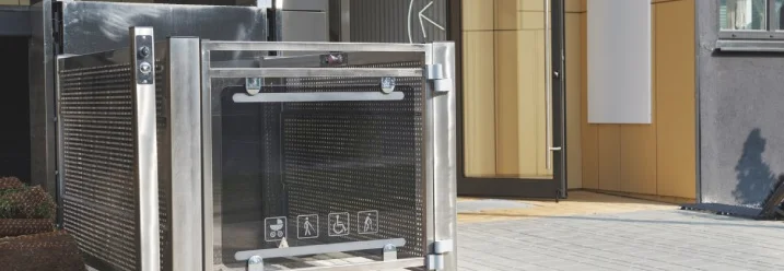 Ein Hublift aus Edelstahl vor einem Hauseingang.